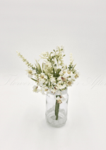 Artificial wedding table arrangement with small cream faux flowers and narrow green leaves in a clear glass jar. Made in Melbourne by Flowers For Ever After, shipping Australia and Worldwide.