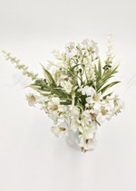 Artificial wedding table arrangement, overhead view of small cream faux flowers and narrow green leaves in a glass jar. Made in Melbourne by Flowers For Ever After, shipping Australia and Worldwide.