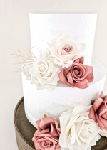 Artificial wedding cake decoration close-up with dusty pink and white faux rose petals and fine pale sprigs. For birthday, event and celebration cakes. Made in Melbourne by Flowers For Ever After, shipping Australia and Worldwide.