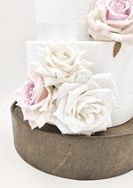 Artificial wedding cake decoration close-up with ivory and pale lavender faux roses clustered at the lower tier. For birthday, event and celebration cakes. Made in Melbourne by Flowers For Ever After, shipping Australia and Worldwide.