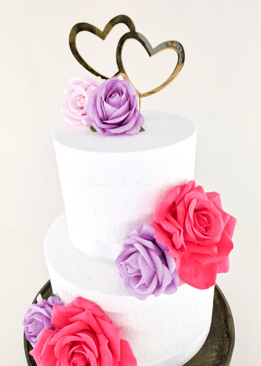 Artificial wedding cake decoration, angled view of faux rose clusters across the tiers. For birthday, event and celebration cakes. Made in Melbourne by Flowers For Ever After, shipping Australia and Worldwide.
