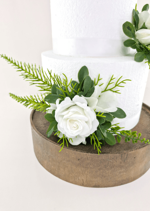 Artificial wedding cake flower close-up with a white faux rose, white orchid petals and fern-like greenery. For birthday, event and celebration cakes. Made in Melbourne by Flowers For Ever After, shipping Australia and Worldwide.