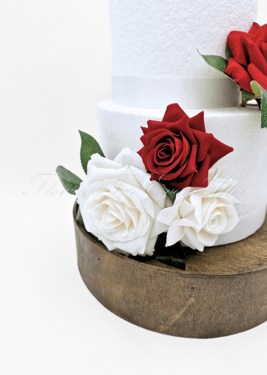 Artificial wedding cake decoration with mixed faux flowers and green foliage arranged across the tiers. For birthday, event and celebration cakes. Made in Melbourne by Flowers For Ever After, shipping Australia and Worldwide.