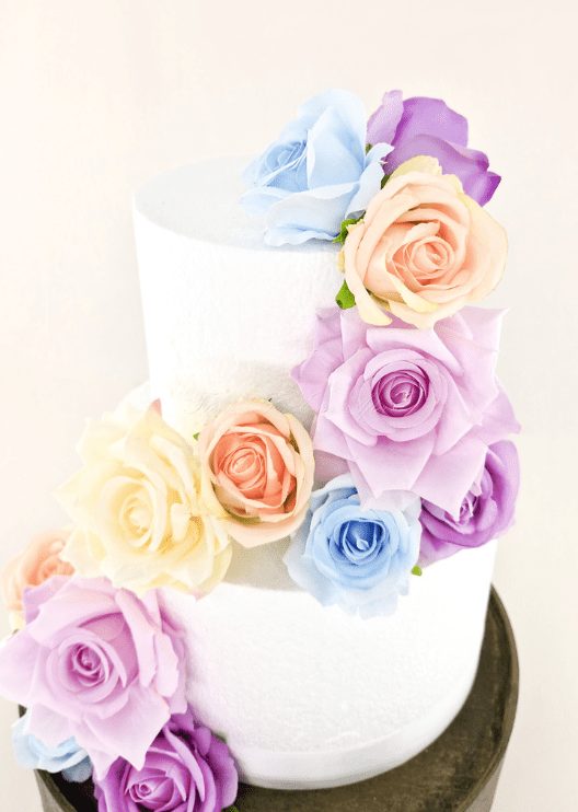 Artificial wedding cake flower decoration with faux rose clusters arranged at the tier edges. For birthday, event and celebration cakes. Made in Melbourne by Flowers For Ever After, shipping Australia and Worldwide.