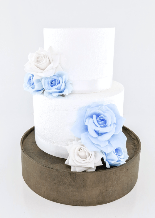 Artificial wedding cake decoration close-up with light blue and white faux roses across two tiers. For birthday, event and celebration cakes. Made in Melbourne by Flowers For Ever After, shipping Australia and Worldwide.
