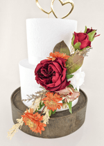 Artificial wedding cake flower close-up with a burgundy faux bloom, orange daisies and bronze-green leaves. For birthday, event and celebration cakes. Made in Melbourne by Flowers For Ever After, shipping Australia and Worldwide.