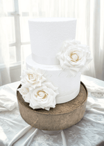 Artificial wedding cake decoration with ivory faux roses and green leaves arranged across two tiers. For birthday, event and celebration cakes. Made in Melbourne by Flowers For Ever After, shipping Australia and Worldwide.