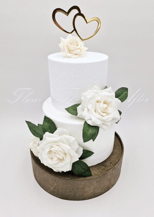 Artificial wedding cake decoration close-up with ivory faux roses and green foliage. For birthday, event and celebration cakes. Made in Melbourne by Flowers For Ever After, shipping Australia and Worldwide.