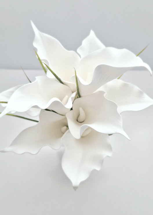 Artificial wedding bouquet close-up showing the curled edges of white faux calla lilies and narrow green leaves. Made in Melbourne by Flowers For Ever After, shipping Australia and Worldwide.