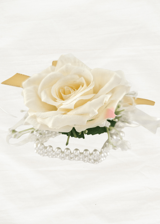 Artificial wedding wrist corsage, low side view of an ivory faux rose, yellow and white ribbons and a pearl-style bracelet. For formals, proms and ball occasions. Made in Melbourne by Flowers For Ever After, shipping Australia and Worldwide.