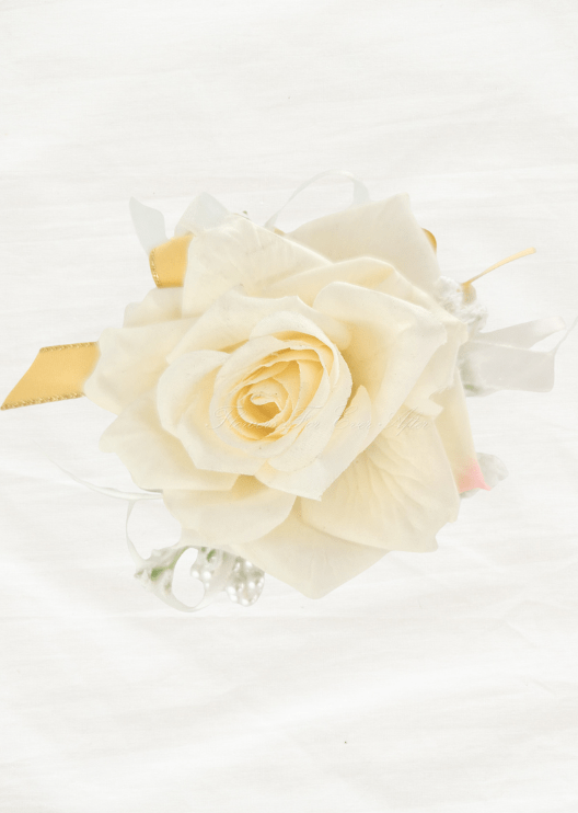 Artificial wedding wrist corsage, overhead view of an open ivory faux rose framed by white and yellow ribbons. For formals, proms and ball occasions. Made in Melbourne by Flowers For Ever After, shipping Australia and Worldwide.