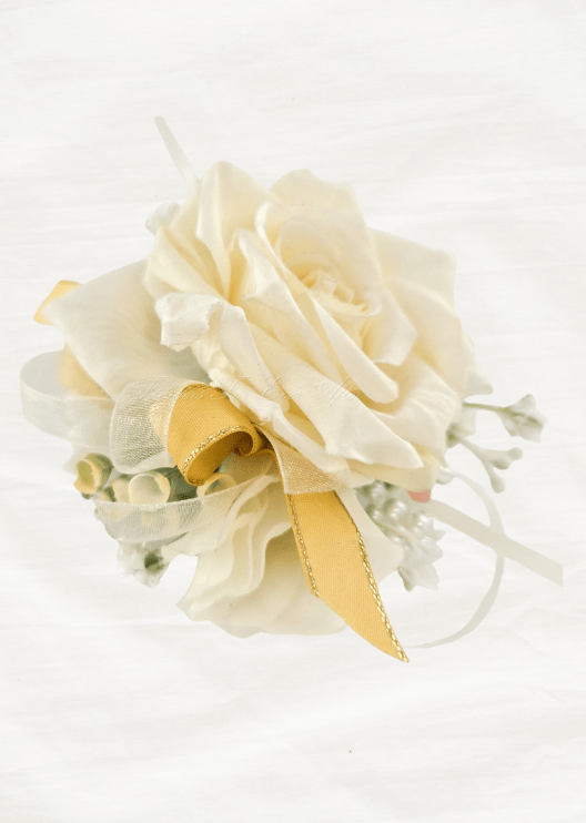 Artificial wedding wrist corsage with an ivory faux rose, pale sprigs, white ribbon and gold-edged yellow ribbon loops. For formals, proms and ball occasions. Made in Melbourne by Flowers For Ever After, shipping Australia and Worldwide.