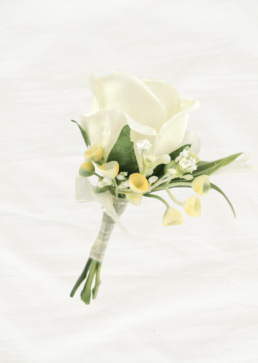 Artificial wedding boutonniere with an ivory faux rose, tiny white blooms, yellow-tipped sprigs, narrow green leaves and ivory-wrapped stems. For formals, proms and ball occasions. Made in Melbourne by Flowers For Ever After, shipping Australia and Worldwide.