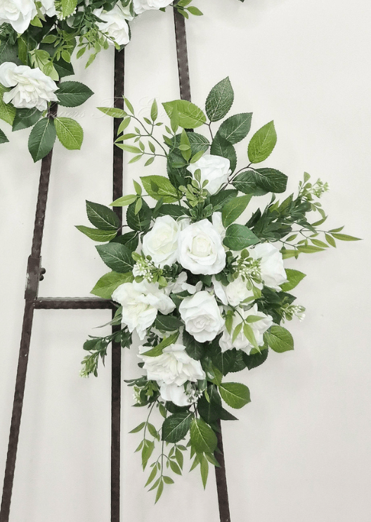 Artificial wedding floral tieback with white faux roses, layered blooms, small buds and spreading green leaves. Made in Melbourne by Flowers For Ever After, shipping Australia and Worldwide.
