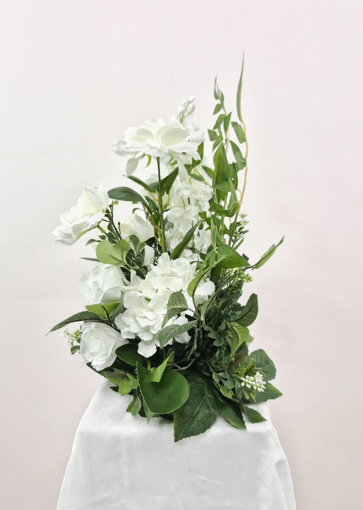 Artificial wedding pedestal arrangement, side view of white faux roses, clustered white blooms, tall flower spikes and green foliage. Made in Melbourne by Flowers For Ever After, shipping Australia and Worldwide.