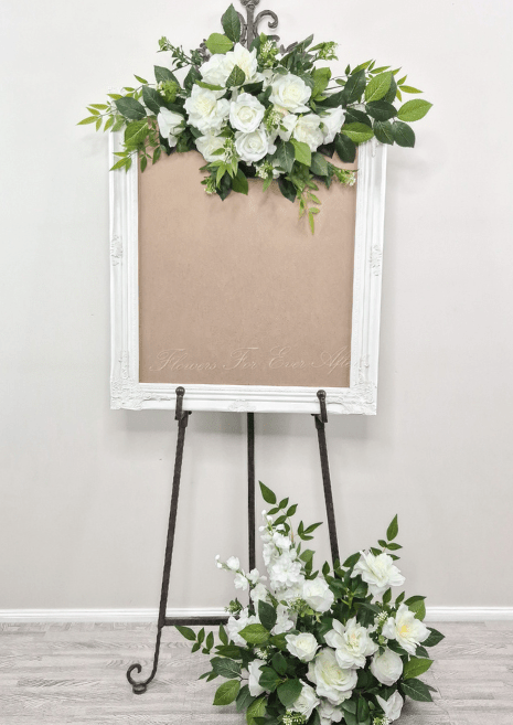 Artificial wedding sign floral set with a centred white faux rose spray, green foliage and matching floor arrangement. Made in Melbourne by Flowers For Ever After, shipping Australia and Worldwide.