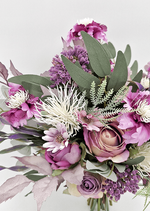 Artificial wedding bridesmaid bouquet close-up with mauve faux roses, purple flowers, white spiky blooms and eucalyptus. Made in Melbourne by Flowers For Ever After, shipping Australia and Worldwide.