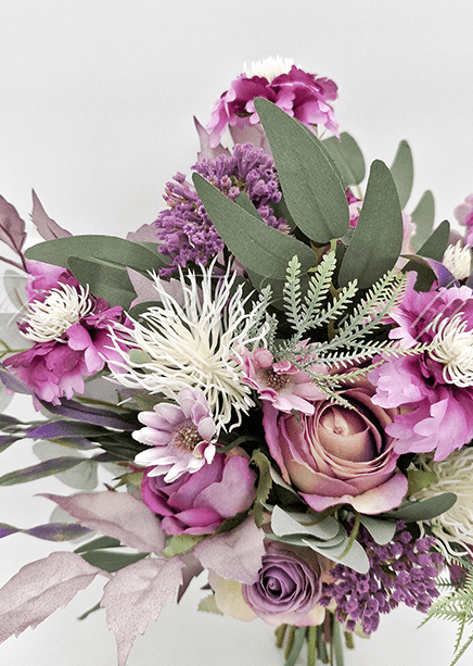 Artificial wedding bridesmaid bouquet close-up with mauve faux roses, purple flowers, white spiky blooms and eucalyptus. Made in Melbourne by Flowers For Ever After, shipping Australia and Worldwide.