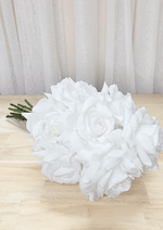 Artificial wedding bridesmaid bouquet laid sideways, showing clustered white faux roses and gathered green stems. Made in Melbourne by Flowers For Ever After, shipping Australia and Worldwide.