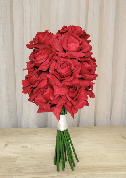 Artificial wedding bouquet with clustered red faux roses, white ribbon wrapping and exposed green stems. Made in Melbourne by Flowers For Ever After, shipping Australia and Worldwide.