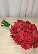 Artificial wedding bouquet laid sideways, showing red faux roses, layered petals and white-wrapped stems. Made in Melbourne by Flowers For Ever After, shipping Australia and Worldwide.