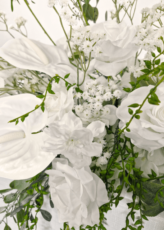 Artificial wedding table garland close-up showing white faux roses, clustered white blooms and green leaves. Made in Melbourne by Flowers For Ever After, shipping Australia and Worldwide.