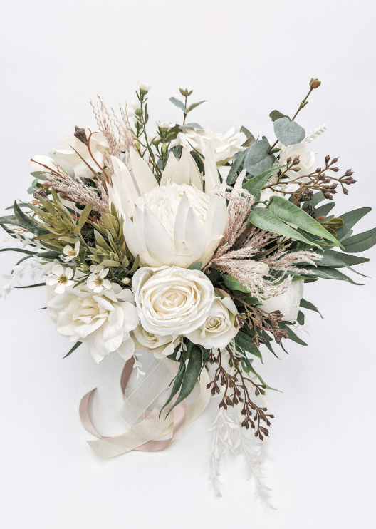 Artificial wedding cake decoration, angled view of faux roses and green foliage across the tiers. For birthday, event and celebration cakes. Made in Melbourne by Flowers For Ever After, shipping Australia and Worldwide.