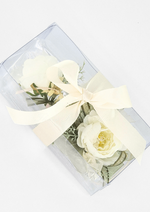 Artificial wedding corsage and boutonniere gift set, overhead view of ivory faux blooms and fine sprigs in a clear ribbon-tied box. For formals, proms and ball occasions. Made in Melbourne by Flowers For Ever After, shipping Australia and Worldwide.