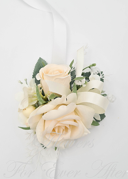 Artificial wedding wrist corsage with cream faux roses, small white flowers, green leaves and ivory ribbon ties. For formals, proms and ball occasions. Made in Melbourne by Flowers For Ever After, shipping Australia and Worldwide.