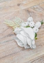 Artificial wedding boutonniere, top view of a white faux rose with small white daisy-like flowers and pale foliage. For formals, proms and ball occasions. Made in Melbourne by Flowers For Ever After, shipping Australia and Worldwide.