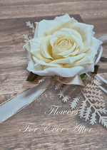 Artificial wedding wrist corsage, angled view of a deep cream faux rose with pale filler flowers, greenery and ivory ribbons. For formals, proms and ball occasions. Made in Melbourne by Flowers For Ever After, shipping Australia and Worldwide.