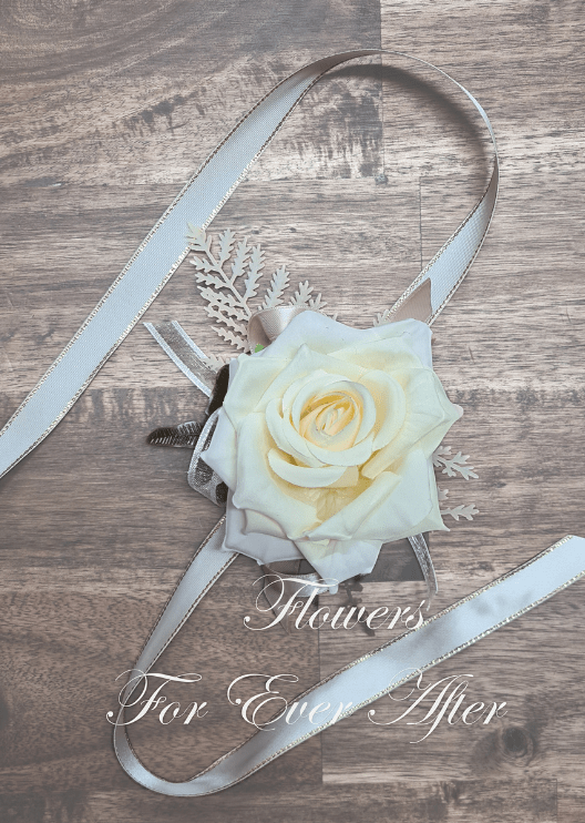 Artificial wedding wrist corsage with a deep cream faux rose, small pale blooms, green leaves and ivory ribbon ties. For formals, proms and ball occasions. Made in Melbourne by Flowers For Ever After, shipping Australia and Worldwide.