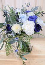 Artificial wedding cascading bouquet with navy, blue and ivory faux roses, white ranunculus, blue sprigs and trailing eucalyptus. Made in Melbourne by Flowers For Ever After, shipping Australia and Worldwide.