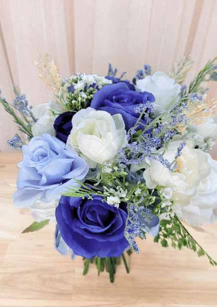 Artificial wedding bouquet, overhead view of blue and ivory faux roses, white ranunculus and fine blue and cream sprigs. Made in Melbourne by Flowers For Ever After, shipping Australia and Worldwide.