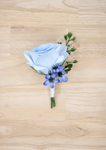 Artificial wedding boutonniere with pale blue faux rose, small blue blossoms, cream sprigs and white-wrapped stem. For formals, proms and ball occasions. Made in Melbourne by Flowers For Ever After, shipping Australia and Worldwide.