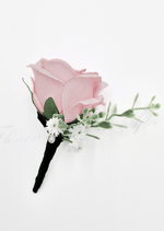 Artificial wedding boutonniere with a pale pink faux rose, small white flowers and green sprigs, with a black-wrapped stem. For formals, proms and ball occasions. Made in Melbourne by Flowers For Ever After, shipping Australia and Worldwide.