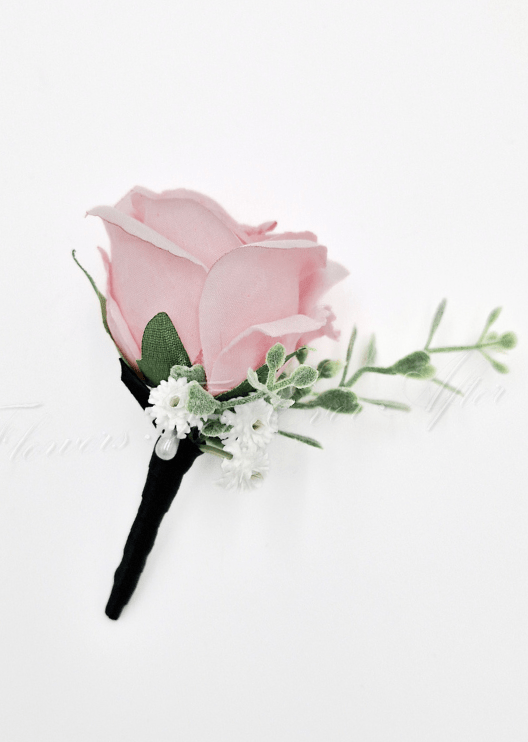 Artificial wedding boutonniere with a pale pink faux rose, small white flowers and green sprigs, with a black-wrapped stem. For formals, proms and ball occasions. Made in Melbourne by Flowers For Ever After, shipping Australia and Worldwide.