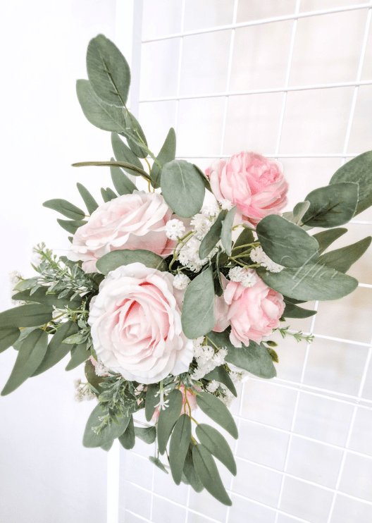 Artificial wedding sign flower arrangement close-up with pale pink faux roses, white blooms and eucalyptus leaves. Made in Melbourne by Flowers For Ever After, shipping Australia and Worldwide.