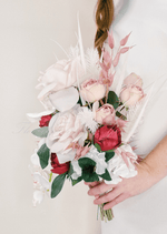 Artificial wedding cascading bridal bouquet, angled view of blush faux roses, red flowers, white orchids and pink foliage. Made in Melbourne by Flowers For Ever After, shipping Australia and Worldwide.