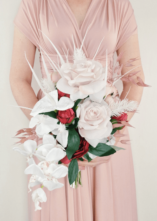 Artificial wedding cascading bridal bouquet with blush faux roses, red blooms, white orchids and trailing pink foliage. Made in Melbourne by Flowers For Ever After, shipping Australia and Worldwide.