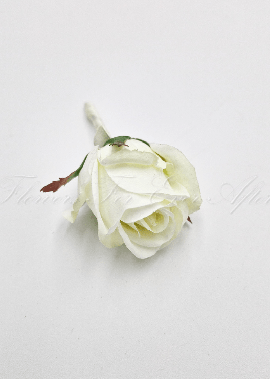 Artificial wedding boutonniere, top view of a white faux rosebud with green sepals and a wrapped stem. For formals, proms and ball occasions. Made in Melbourne by Flowers For Ever After, shipping Australia and Worldwide.