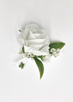 Artificial wedding boutonniere, top view of a white faux rose, white berry sprigs and green leaves. For formals, proms and ball occasions. Made in Melbourne by Flowers For Ever After, shipping Australia and Worldwide.
