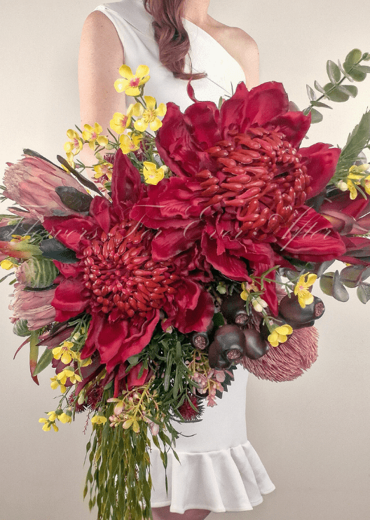 Artificial wedding bridal bouquet close-up with red faux waratah, pink protea, yellow flowers, eucalyptus and dark seed pods. Made in Melbourne by Flowers For Ever After, shipping Australia and Worldwide.