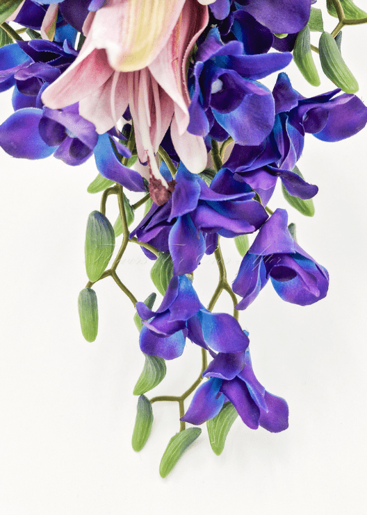 Artificial wedding bridesmaid posy, angled view of pink faux lilies, purple orchids and green leaves. Made in Melbourne by Flowers For Ever After, shipping Australia and Worldwide.