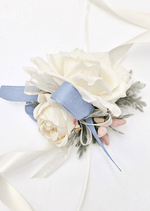 Artificial wedding wrist corsage with cream faux roses, dusty blue ribbon loops, pink berry sprigs and trailing ivory ribbons. For formals, proms and ball occasions. Made in Melbourne by Flowers For Ever After, shipping Australia and Worldwide.