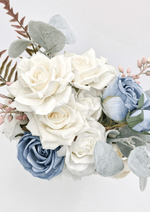 Artificial wedding bridesmaid bouquet close-up with cream and dusty blue faux roses, eucalyptus leaves and pink berry sprigs. Made in Melbourne by Flowers For Ever After, shipping Australia and Worldwide.