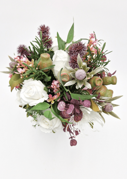 Artificial wedding bridesmaid bouquet, angled view of native-style faux flowers and green foliage. Made in Melbourne by Flowers For Ever After, shipping Australia and Worldwide.