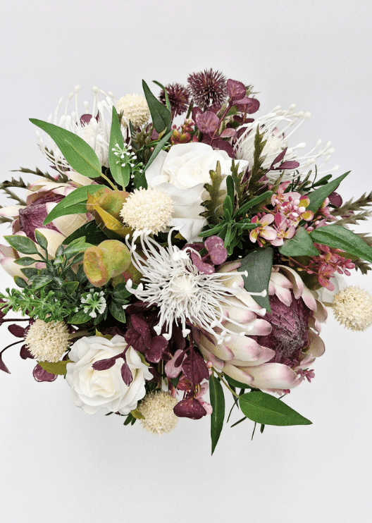 Artificial wedding bridal bouquet close-up showing native-style faux flowers and green leaves. Made in Melbourne by Flowers For Ever After, shipping Australia and Worldwide.