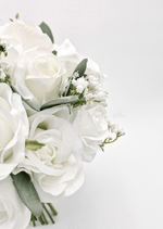 Artificial wedding bouquet close-up showing white faux roses, white blooms, small filler flowers and eucalyptus. Made in Melbourne by Flowers For Ever After, shipping Australia and Worldwide.