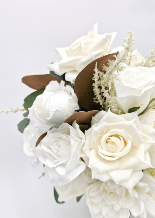 Artificial wedding bouquet close-up with ivory faux roses, white blooms, pale sprigs and brown magnolia leaves. Made in Melbourne by Flowers For Ever After, shipping Australia and Worldwide.
